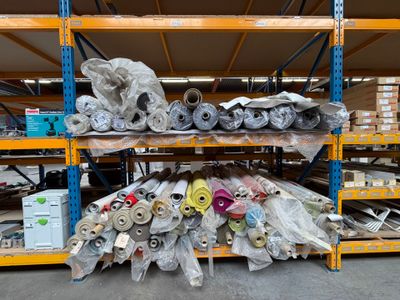 de nombreux rouleaux de tissu sur les étagères de l'entrepôt