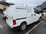 une camionnette blanche garée sur un parking, avec les montagnes en arrière-plan