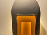 un grand vase gris dans lequel brille une lumière jaune