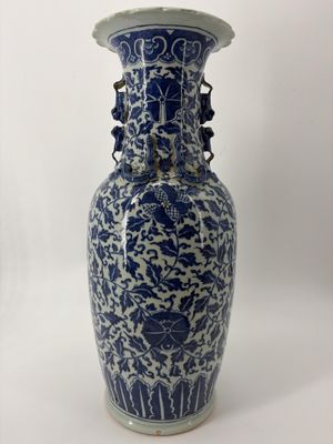 un vase bleu et blanc posé sur une surface blanche