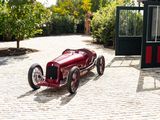 a red car that is sitting on a cobblestone road