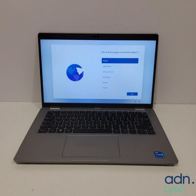 un ordinateur portable ouvert posé sur une table blanche