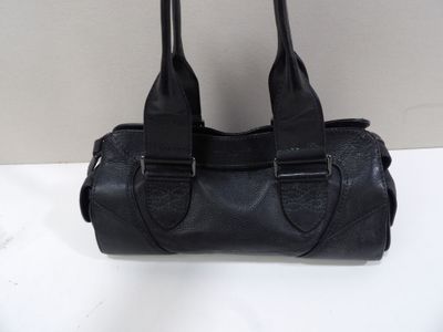 black leather handbag with two handles on a white surface