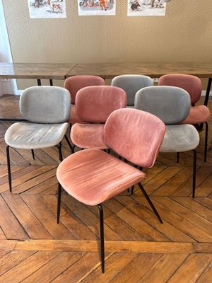 Plusieurs chaises sont alignées en rangée sur un plancher en bois