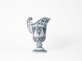 blue and white vase on a white surface with a white background