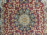 a red and blue rug with a medallion design on it