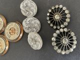several different types of buttons and brooches on a table