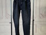 a pair of jeans hanging on a clothes rack in a room