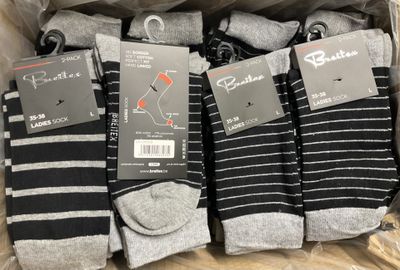 six pairs of men ' s socks in a box with tags on them