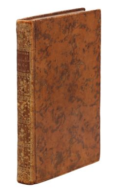 un vieux livre à la couverture brune posé sur une surface blanche