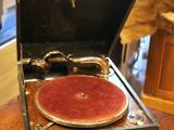 a teddy bear sitting on a table next to an old record player