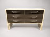 a white and brown chest of drawers on a grey background