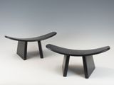 une paire de bancs en bois noirs posés sur une surface blanche