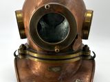 un gros plan d'un casque de plongée en cuivre sur fond blanc