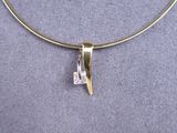 a close up of a necklace with a diamond on it