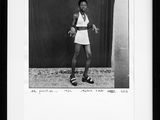 black and white photograph of a woman in a tennis outfit holding a tennis racquet