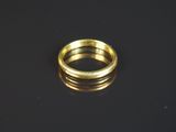gros plan d'une bague en or sur une surface noire