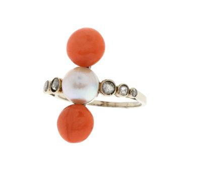 un gros plan d'une bague ornée d'une perle et d'un corail