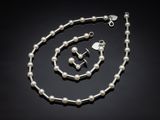 un gros plan d'un collier et d'un bracelet ornés de perles sur fond noir