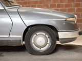 a silver car that is parked in front of a brick wall