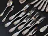 many forks and spoons laid out on a table