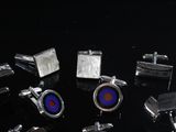many different types of cufflinks on a black surface