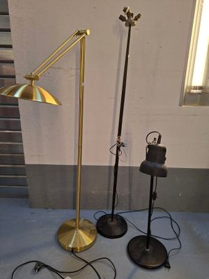 trois lampadaires et un pied de lampe dans une pièce