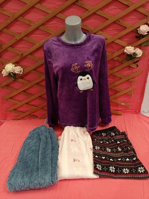 purple sweater with penguin applique and matching pants on a pink bed