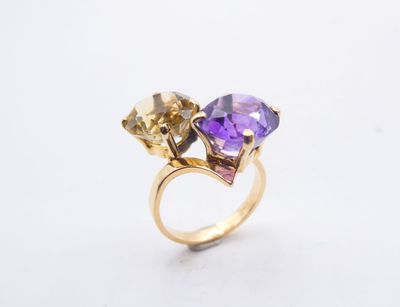 a close up of a gold ring with two different colored stones