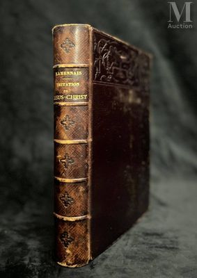 an old book sitting on top of a black cloth covered table