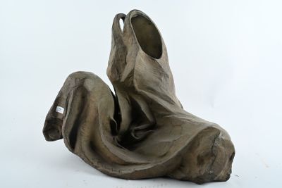 une sculpture représentant une personne assise sur une surface blanche