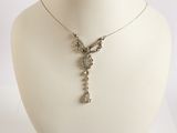 a white mannequin with a silver necklace on it