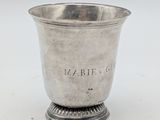 an antique silver cup on a pedestal on a white background