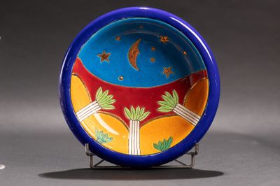 une assiette bleue décorée d'un motif, à côté d'un verre de vin