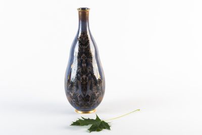 un vase noir avec une feuille posée par terre