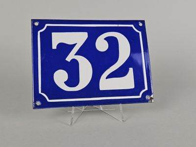 une photo d'une plaque de numéro de maison bleue et blanche fixée sur un support métallique