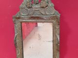 un miroir accroché à un mur rouge, entouré d'une chaîne