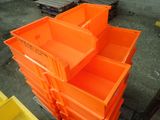 many orange plastic containers stacked on top of each other