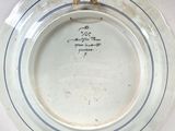 a white plate with blue stripes on it on a table