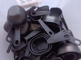 a lot of black kitchen utensils in a plastic container