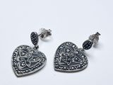 une paire de boucles d'oreilles en forme de cœur, ornées de diamants noirs et blancs