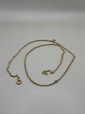 a close up of a gold chain on a white surface