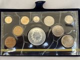 un assortiment de pièces de monnaie dans un étui en plastique posé sur une surface blanche
