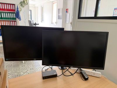 deux écrans posés l'un à côté de l'autre sur un bureau