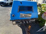 a blue truck that is parked next to a building