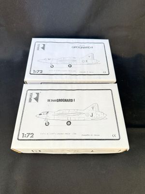 deux boîtes d'avions en papier à assembler posées sur une surface noire