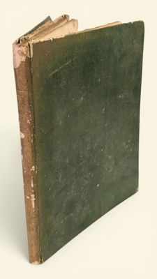 un vieux livre à la couverture verte posé sur une surface blanche
