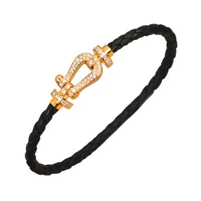 a black braid bracelet with a gold clasp and a diamond clasp