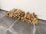 un tas de bois posé par terre près d'un mur