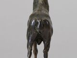 statue of a bull standing on a rock on a white surface